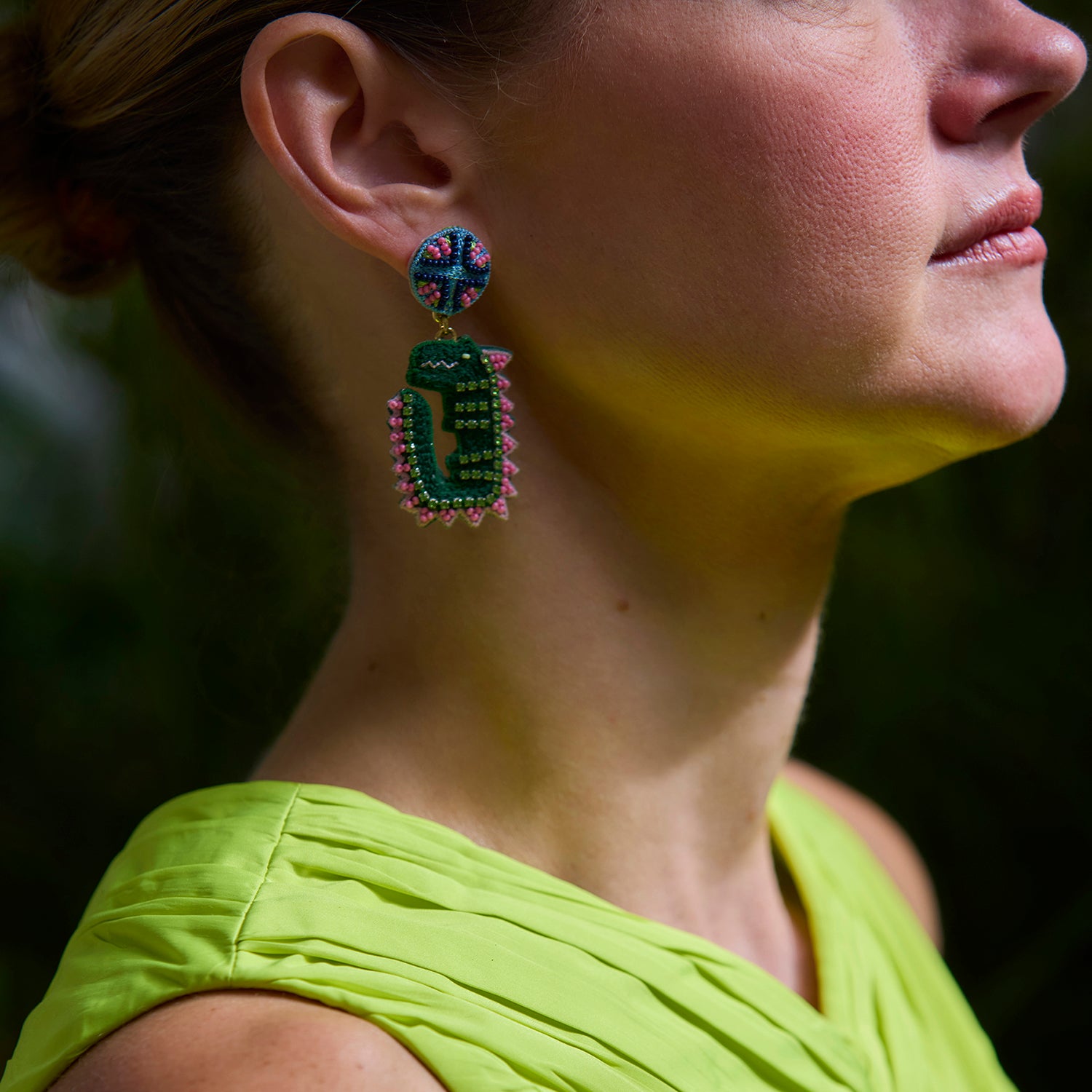 Model Wearing Leslie Earrings against dark background in yellow dress. 