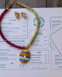 Colorful beaded necklace on a menu with 'Coral Sands Beach Bar' branding.