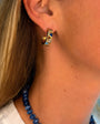 Model wearing gold and sapphire hoop earrings