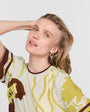 Woman wearing a patterned shirt with a plain background