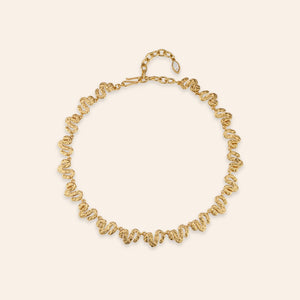 Antiqued Gold Collar Necklace on Tan Background