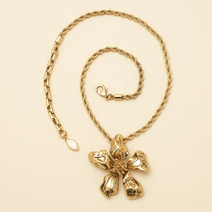 Gold Flower Pendant Necklace on Flat Cream Background