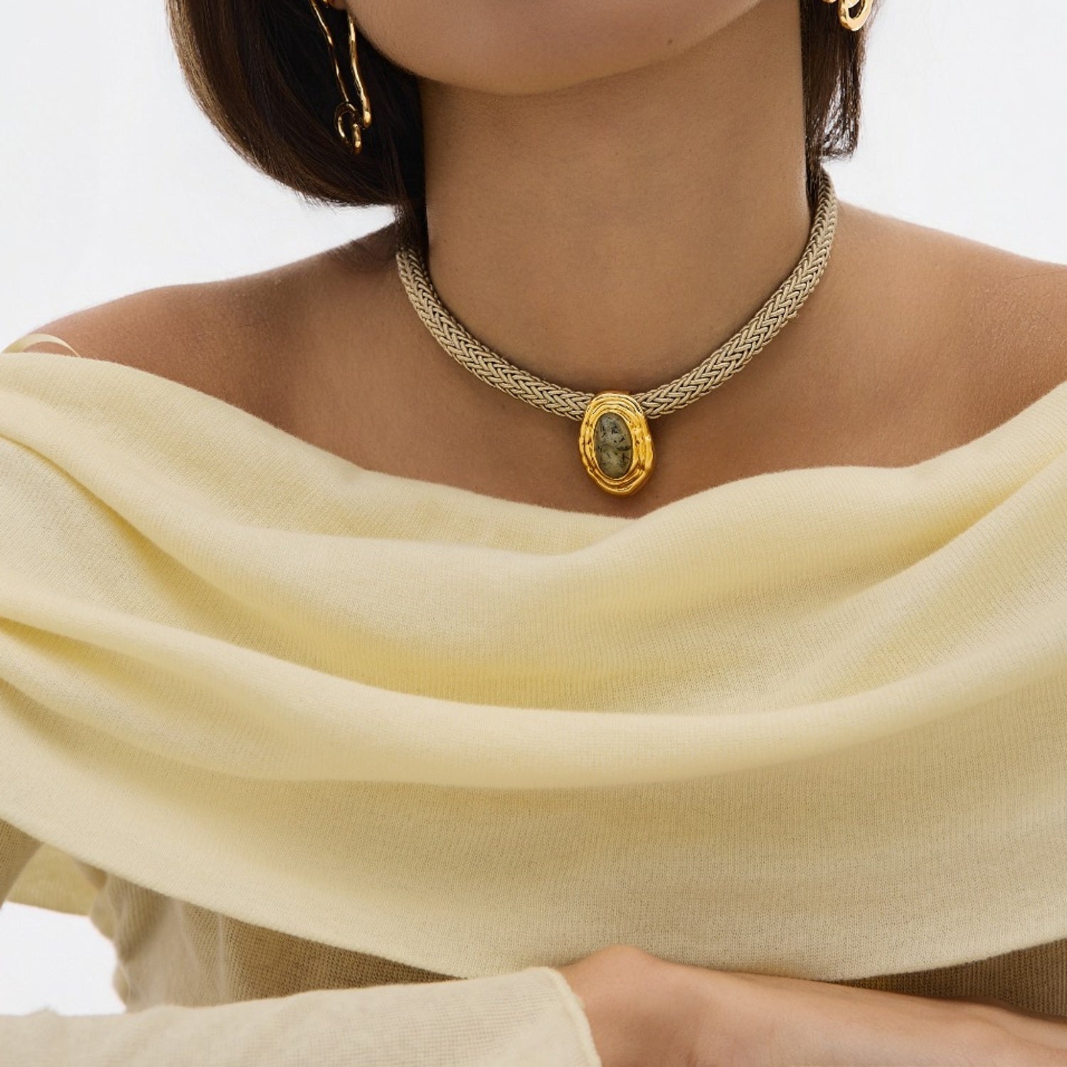 Necklace with a pendant worn by a person, with a neutral background