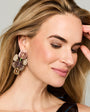 Model earring floral shaped light weight embroidered earring against a white background