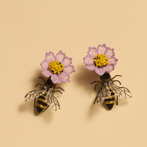 Purple and Yellow Flower and Bee Drop Earrings Staged on Flat Cream Background