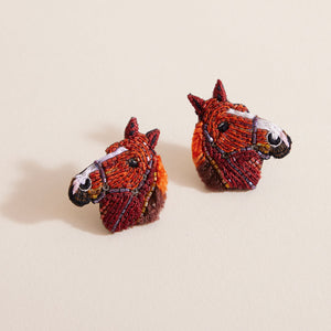Brown and White Horse Stud Earrings Styled on Cream Background