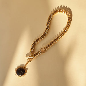 Black Globe Charm Chain Pendant Charm Necklace Staged on Tan Background with Shadows