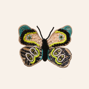 Teal, Black, Gold, and Neon Yellow Beaded and Embroidered Butterfly Brooch on Tan Background