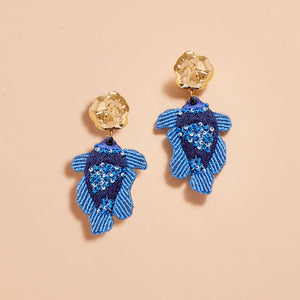Blue Beaded and Embroidered Fish Drop Earrings with Gold Top on Tan Background