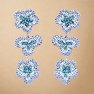 Blue Beaded Flower Drop Earrings on Tan Background