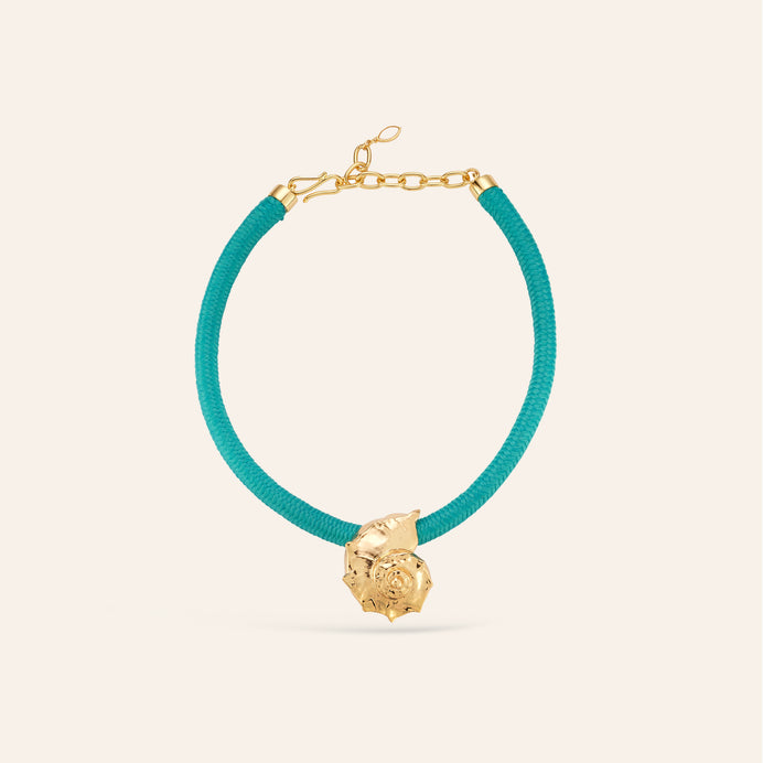 Turquoise Cord and Gold Shell Charm Pendant Necklace on Cream Background