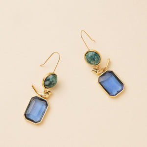 Blue Crystal and Green Stone Drop Earrings Staged on Flat Cream Background