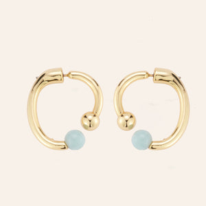 Blue Semi-Precious Stone and Gold Hoop Earrings on Tan Background