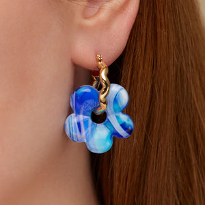 Blue and White Marbled Glass Flower Charm Earrings on Gold Hoops on Model's Ear