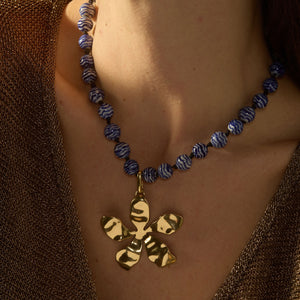 Blue and White Marbled Glass Bead Strand with Gold Organic Flower Pendant Charm Styled on Model