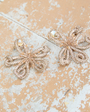 Gold beaded and embroidered earrings on stone background