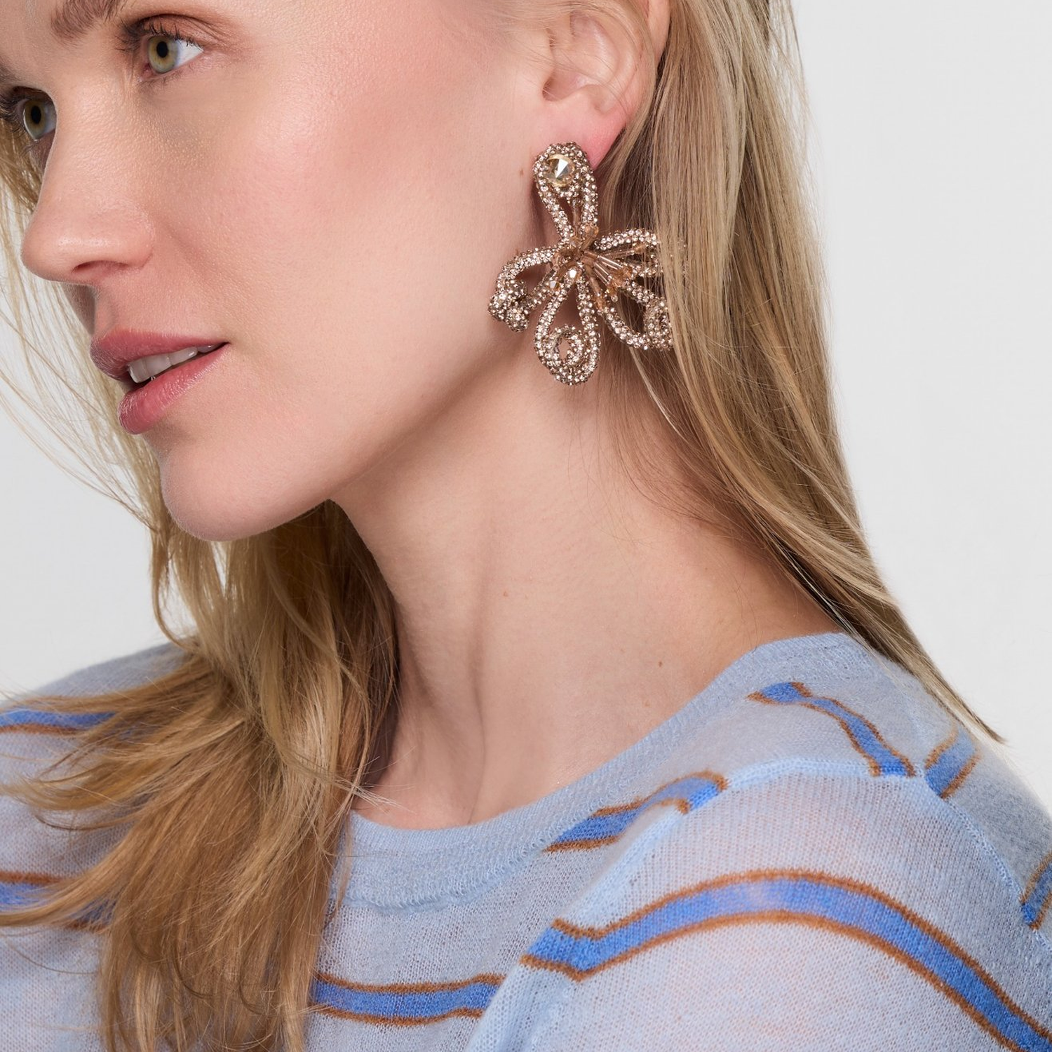 Gold beaded earrings on model