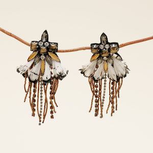 Black, White, and Bronze Feather and Crystal Drop Earrings Staged on Branch with Cream Background