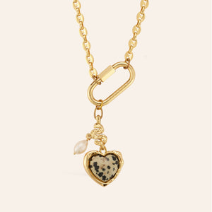 Stone, Pearl, and Gold Charm Pendant Necklace on Tan Background