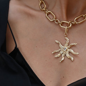 Gold Sun Star Charm on Gold Chain On Model's Chest 