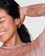 Woman wearing a patterned top with a plain background