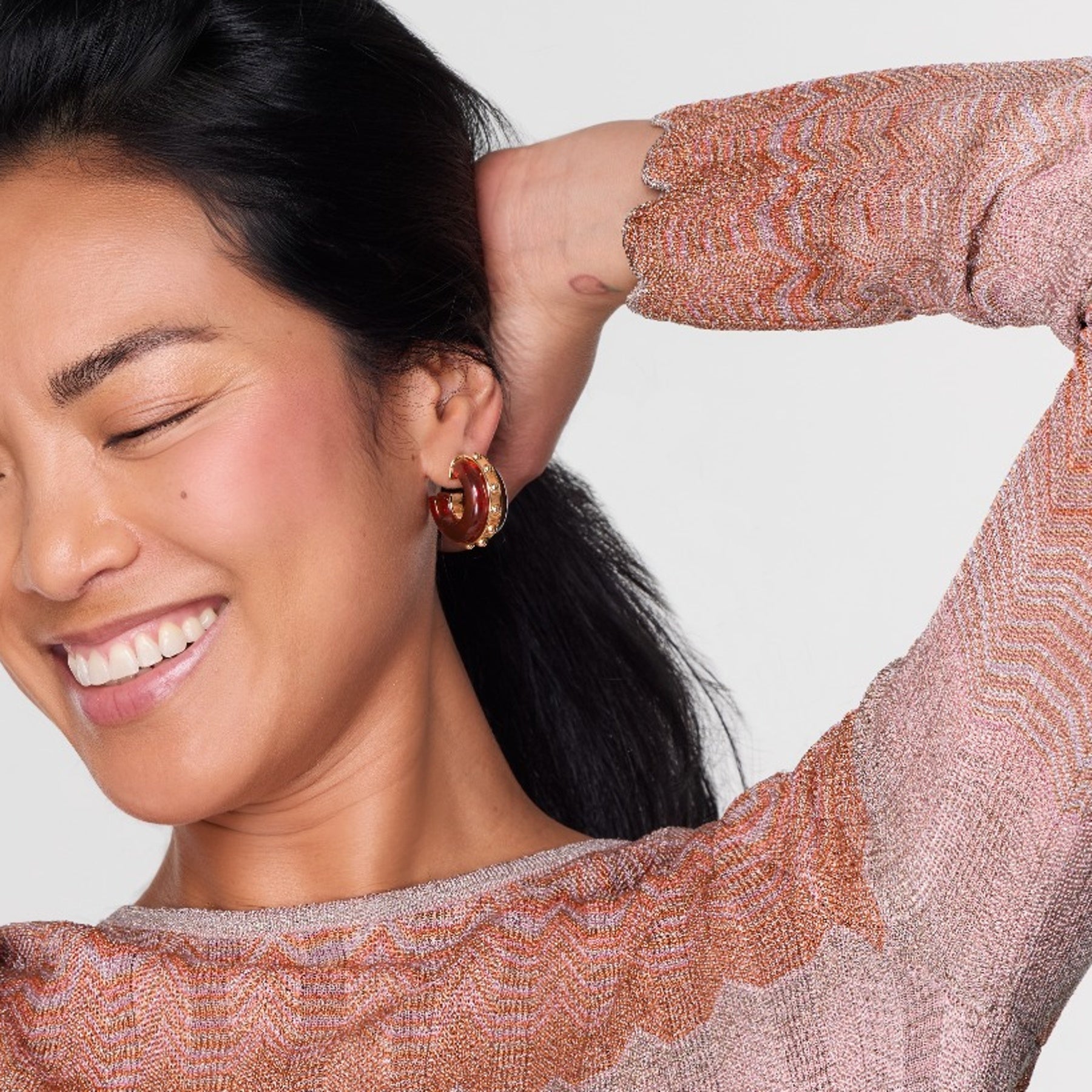 Woman wearing a patterned top with a plain background