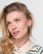 Blonde model wearing striped shirt and glass green earring studs. 
