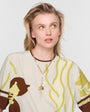 Model wearing gold chain charm necklace on white background