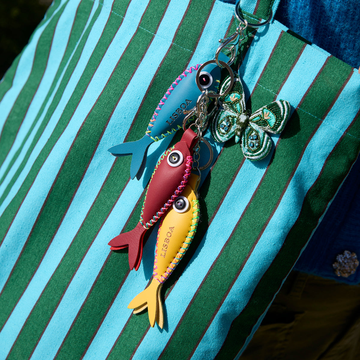 Green Butterfly Beaded and Embroidered Brooch styled on a green and blue striped bag 