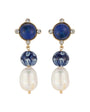 A pair of gold-tone drop earrings featuring round navy blue lapis lazuli stones, patterned blue and white beads, and large white baroque pearls, set against a plain white background.