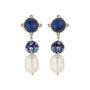 A pair of gold-tone drop earrings featuring round navy blue lapis lazuli stones, patterned blue and white beads, and large white baroque pearls, set against a plain white background.