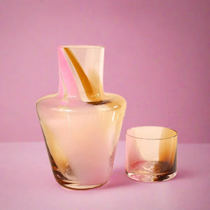 Pink, Amber, and Clear Glass Decanter with Cup on Pink Background