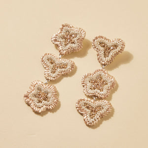 Ivory and Cream Beaded Flower Drop Earrings on Cream Flat Background