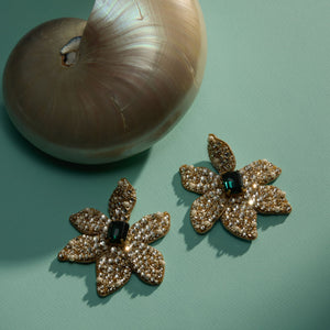 Crystal Pearl Embroidered Flower Drop Earrings Staged with a Shell on Green Surface