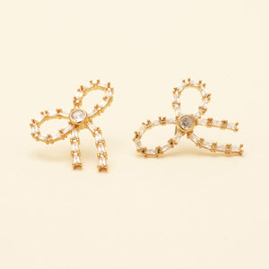 Crystal and Gold Bow Stud Earrings On Cream Background