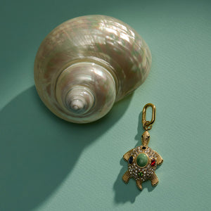 Bejeweled Crystal and Stone Turtle Charm Staged with Shell on Green Surface