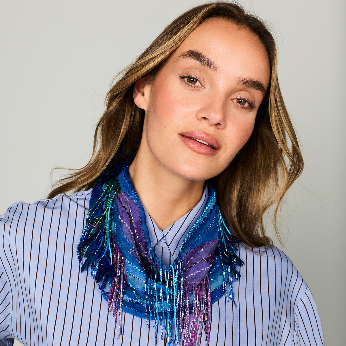 Blue patterned, beaded and embroidered scarf necklace featuring colorful pink and purple details on model Close Up
