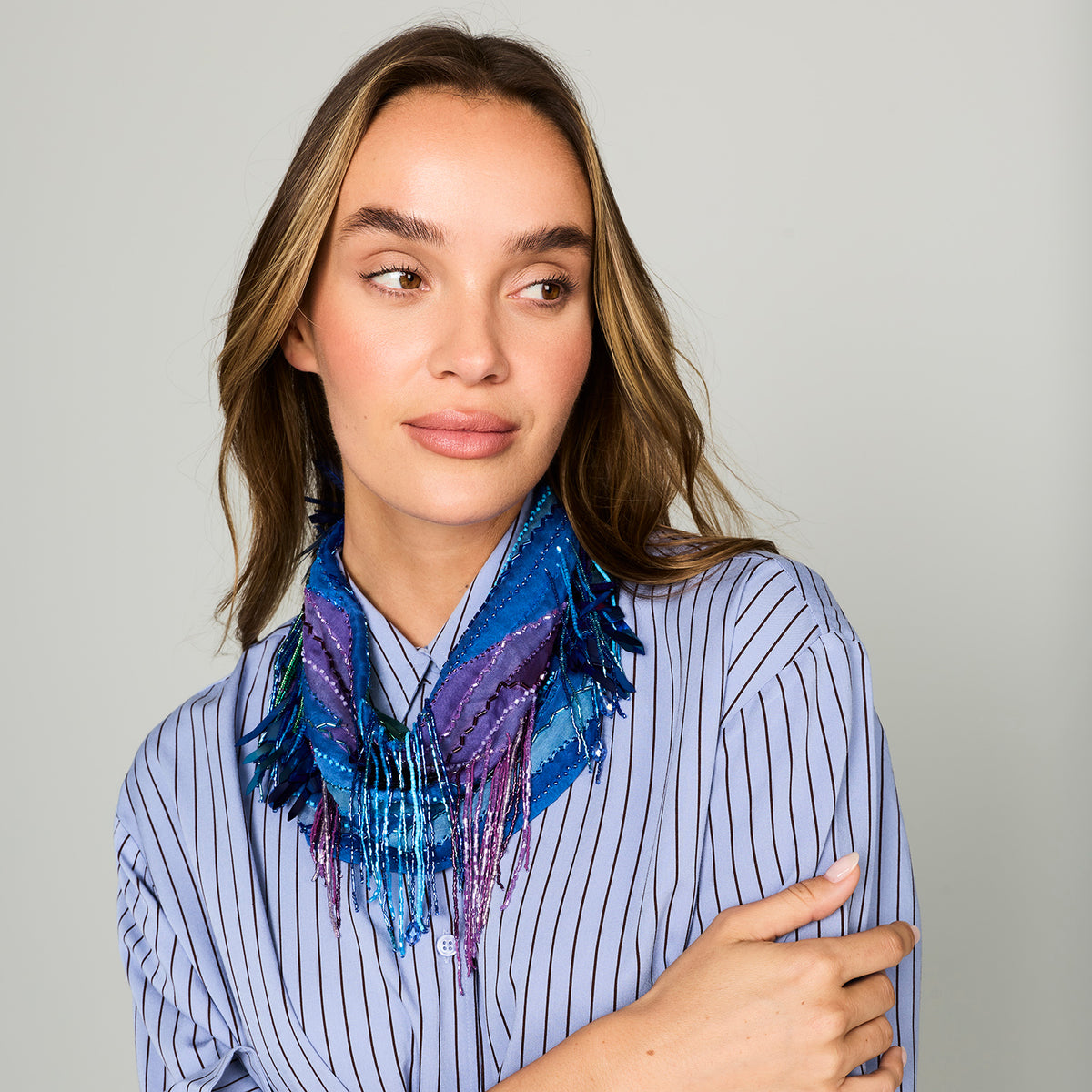 Blue patterned, beaded and embroidered scarf necklace featuring colorful pink and purple details on model