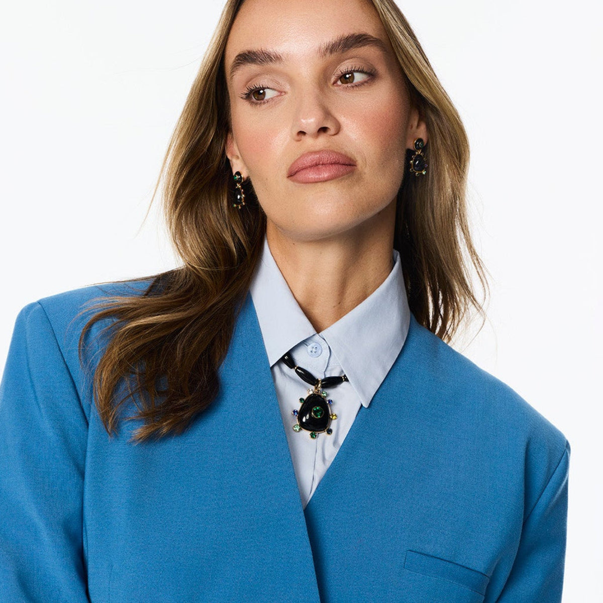 Black beaded necklace featuring a gold-tone Semi Precious Black Onyx pendant with green, navy, blue and clear accents on model