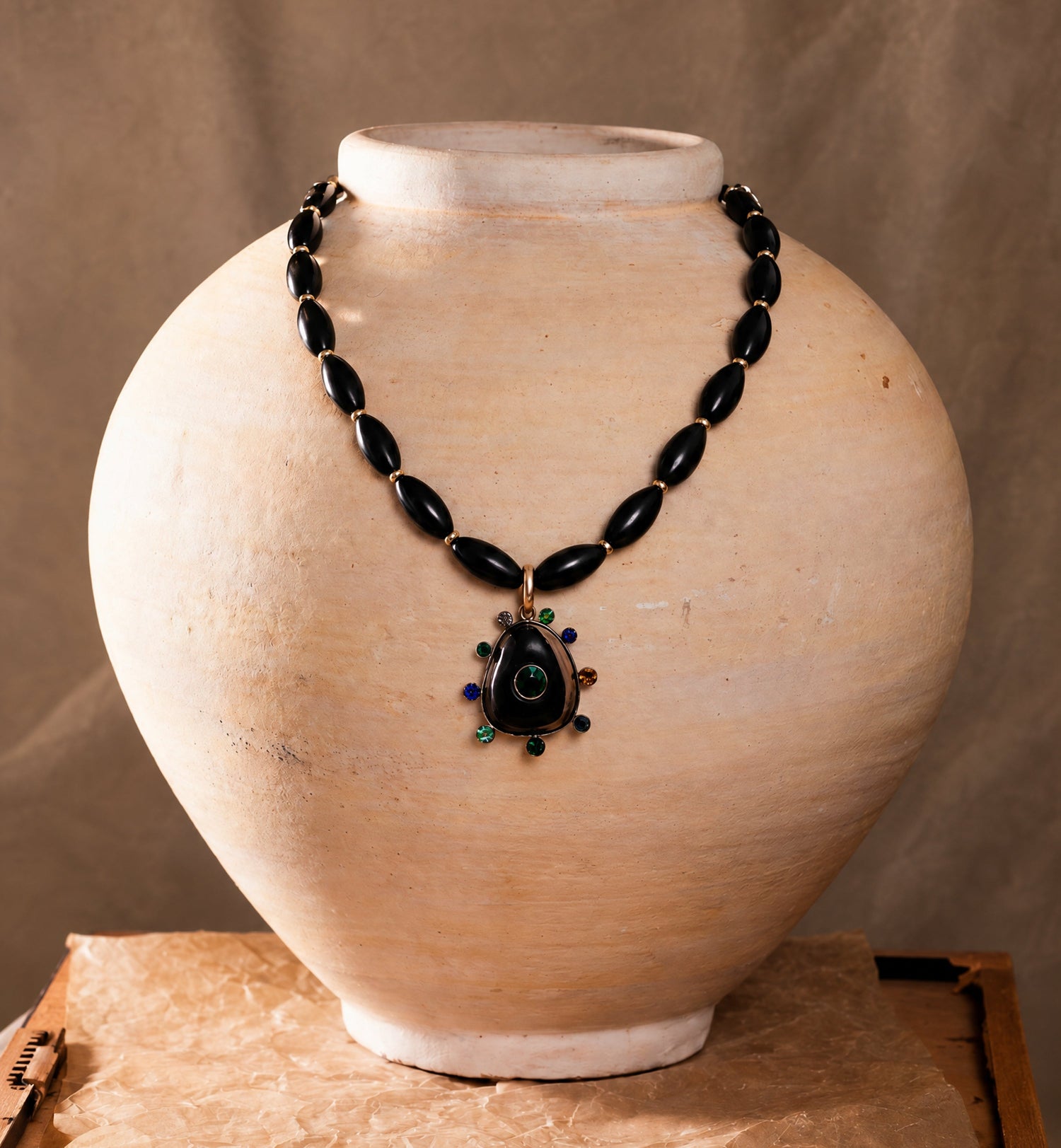 Black Onyx statement necklace on a pot with a beige background