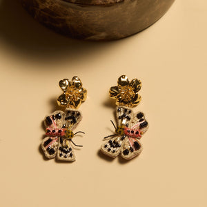 Embroidered and Beaded Butterfly. Drop Earrings Staged on Cream Background with Shadows