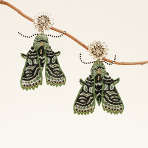 Emerald and Black Beaded and Embroidered Moth Drop Earrings with Champagne Crystal Topper Staged on Branch with Tan Background