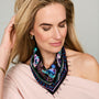 Black scarf necklace featuring colorful floral and geometric embroidery with beaded details on model close up 