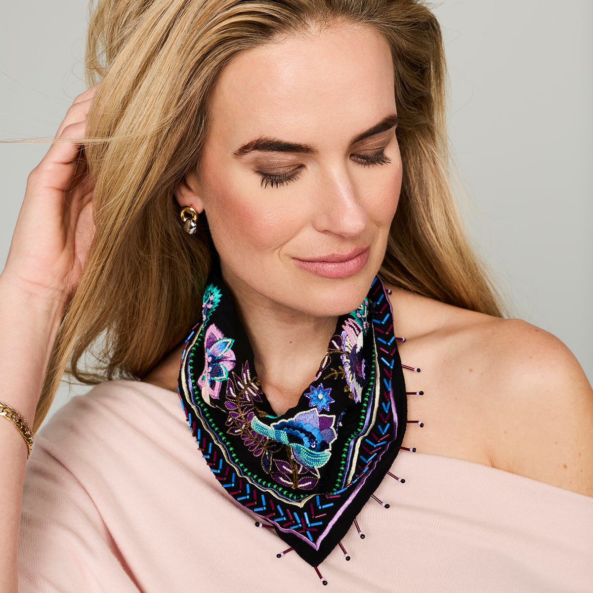 Black scarf necklace featuring colorful floral and geometric embroidery with beaded details on model close up 