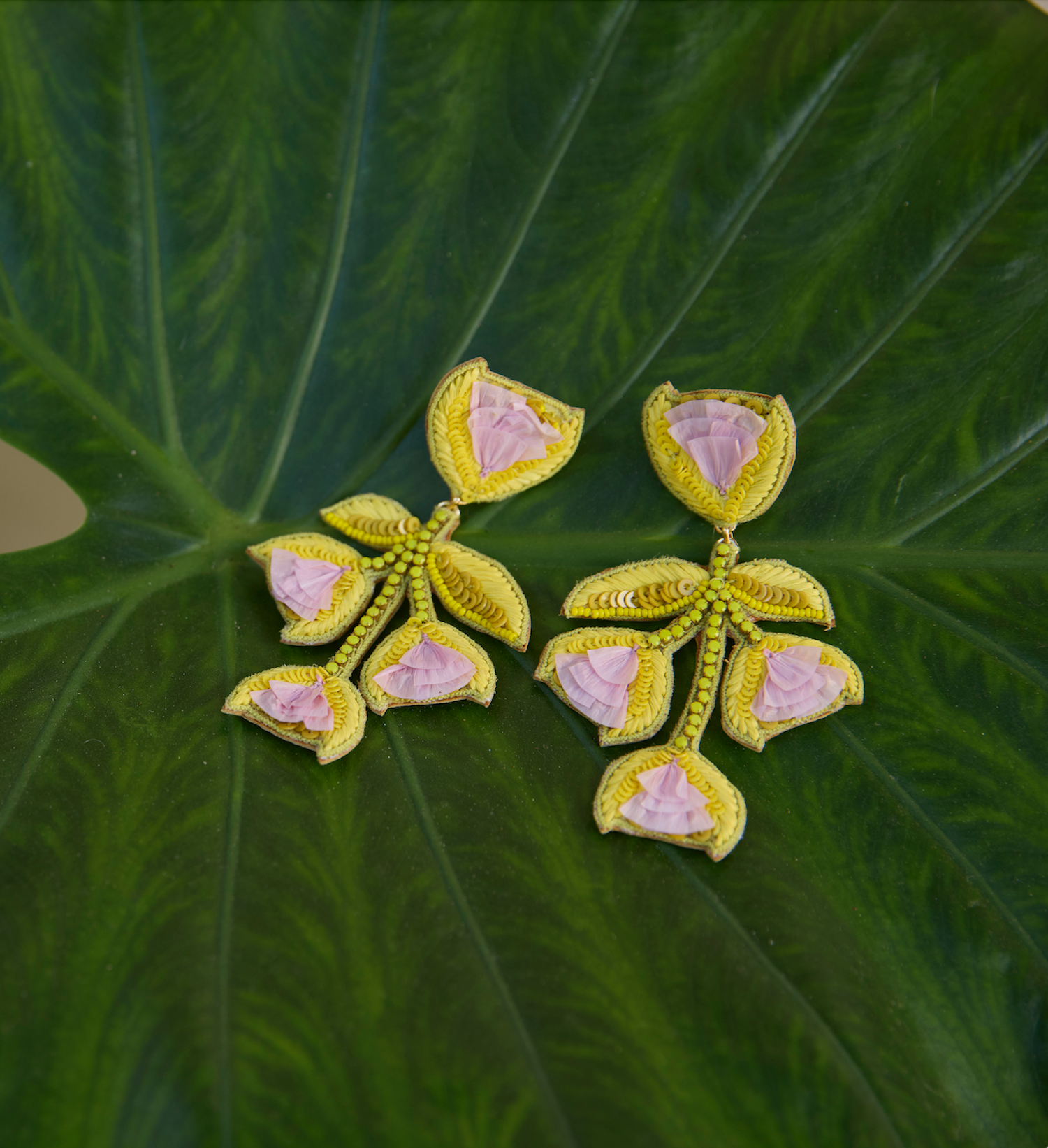 Floral-shaped earrings against greeny leafy background