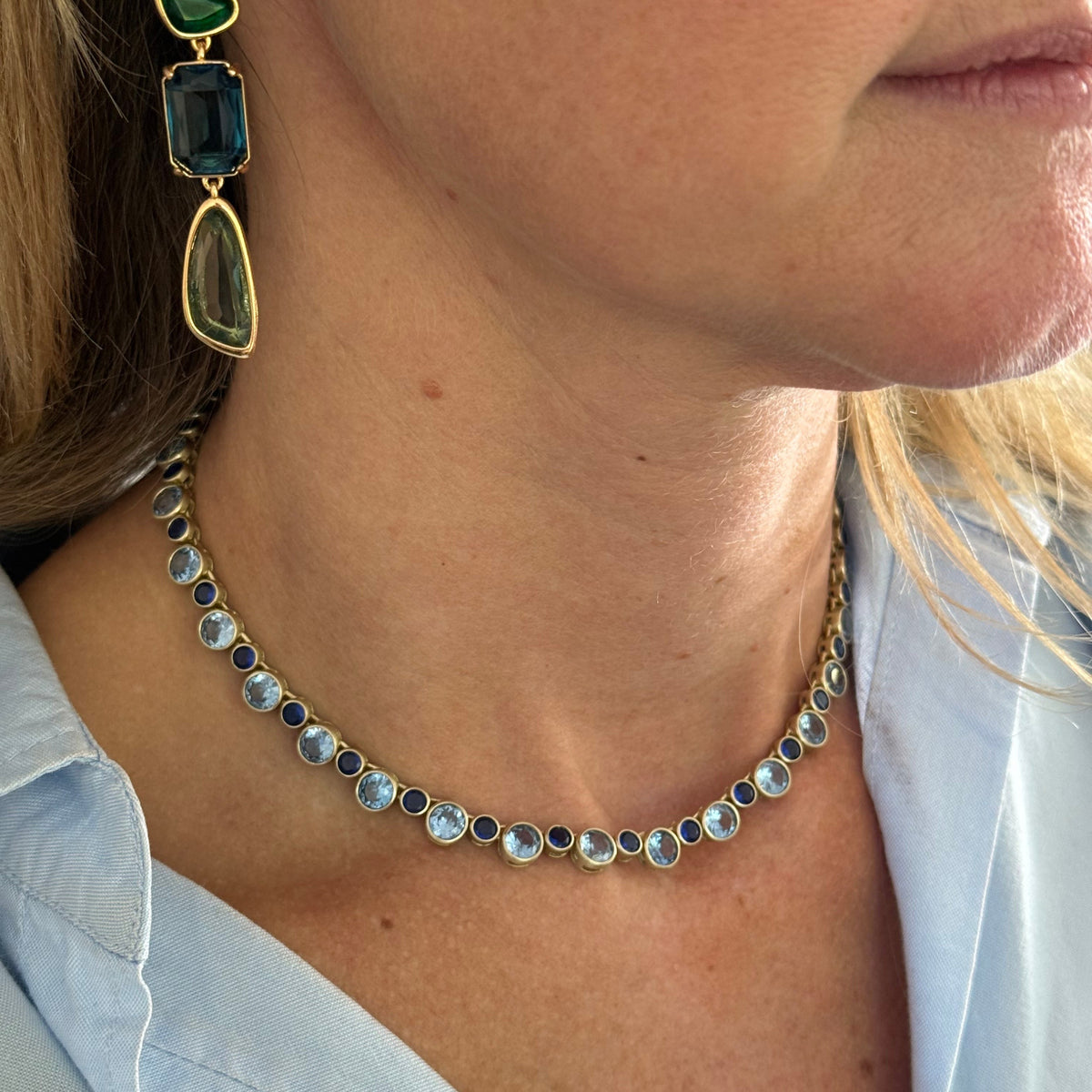Delicate necklace featuring a strand of small blue beads and a gold-tone clasp on Mignonne Gavigan closeup
