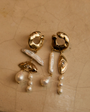 Pearl and Gold Statement earrings against stone background