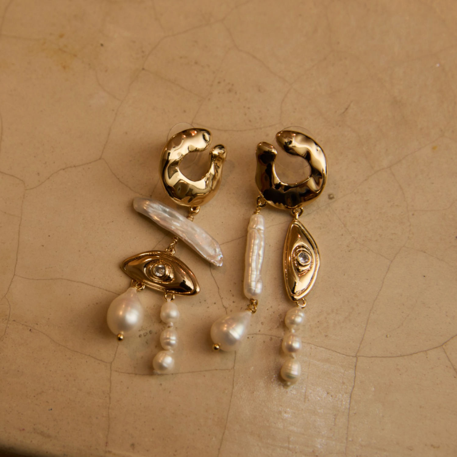 Pearl and Gold Statement earrings against stone background