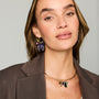 Multicolor butterfly-shaped statement earrings featuring purple, blue, and green beadwork with gold-tone details on Model straight on 