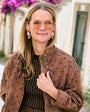 Model wearing fox embroidered and beaded earrings against a downtown background